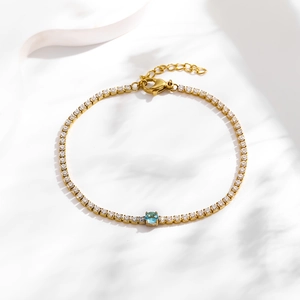 Gold titanium bracelet with white pave zircons and a light blue round centerpiece