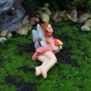 Garden flower fairy resin figurine with pink dress and blue wings on mossy stone