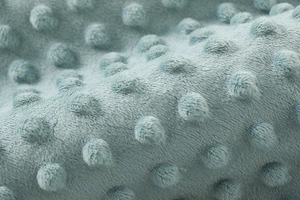 Dettaglio macro del morbido tessuto felpato minky dot azzurro per neonati