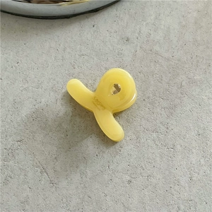 Detailed macro view of a yellow acetate hair claw clip with a glossy jelly finish