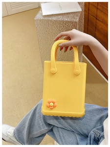 Detailansicht der gelben EVA-Strandtasche mit dekorativer orangefarbener Blumenapplikation