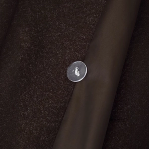 Deep brown wool coat with satin piping details and a transparent round button