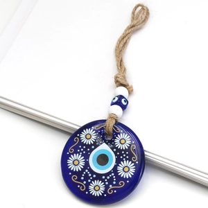 Close-up of blue glass Evil Eye pendant with white and yellow floral patterns on hemp rope