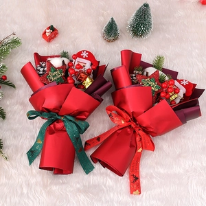 Christmas bouquet with artificial berries, pine cones and Santa dolls in gift packaging