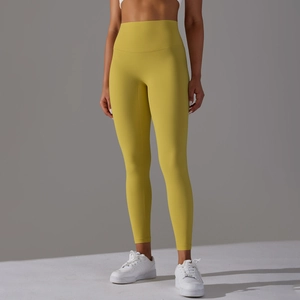 Detail view of mustard yellow high-waisted yoga leggings showing tummy control and seamless design