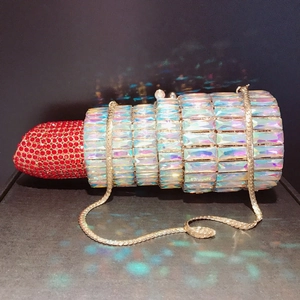 Detailed close-up of a lipstick-shaped clutch with red and holographic rhinestones