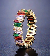 Macro view of gold plated ring featuring colorful baguette cut cubic zirconia stones
