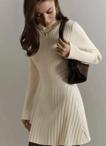 Detail of cream long sleeve knit dress showing vertical texture and elegant styling