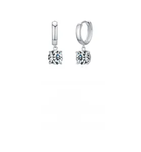 Macro shot of silver Moissanite earrings with hoop design and four-prong gemstone setting