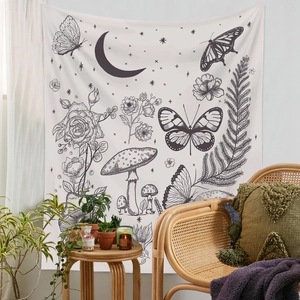 Bohemian black and white line art tapestry with butterfly and floral motifs in a cozy room