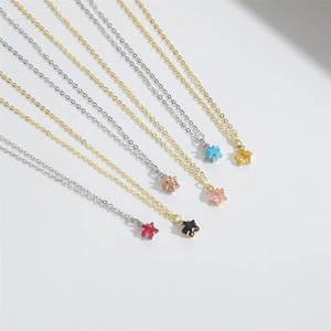 Macro view of five-pointed star pendant necklaces in various gem colors and gold chain