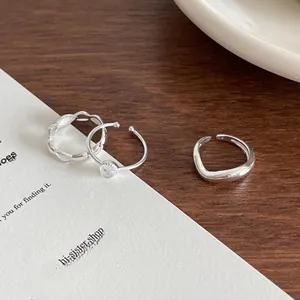 Close-up of minimalist 925 sterling silver rings set with irregular band and gemstone detail