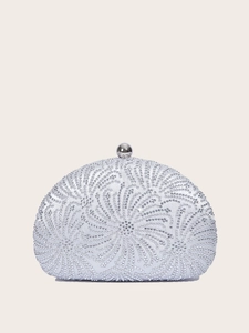 Detail of silver shell clutch bag featuring intricate floral rhinestone patterns and metal clasp