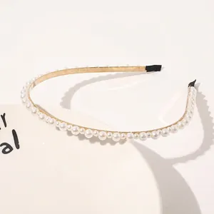Detail of gold pearl headband with alternating size pearls and soft protective end caps