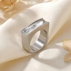 Macro detail of silver brushed steel ring featuring a clear rectangular crystal stone