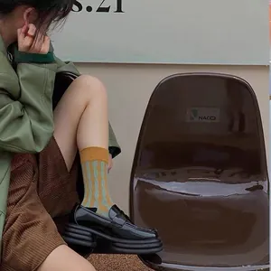 Détail de mocassins noirs à plateforme brillants avec chaussettes en tricot à rayures