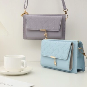 Detalle de bolsos bandolera de piel PU gris y azul con colgantes de hojas y acolchado