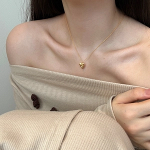 Close-up of a gold S925 sterling silver heart necklace with zircon on a model