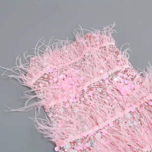 Detail of pink sequins embroidery and soft ostrich feather trim on an elegant party dress