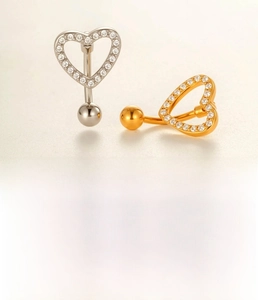 Detailed view of silver and gold heart belly rings with zircon stones in titanium steel