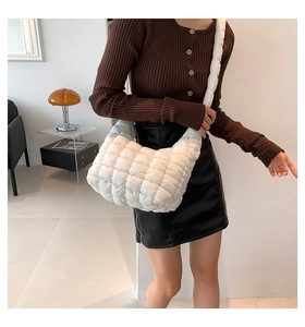 Close-up of a white quilted cloud bag featuring soft padded texture and wide shoulder strap