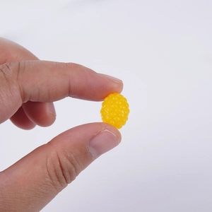 Miniature resin pineapple slice model for DIY crafts shown being held by a finger