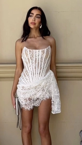Detailed close-up of white floral lace texture and corset boning on the strapless dress