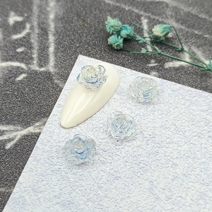Macro view of transparent iridescent 3D camellia resin flower charms for DIY nail art