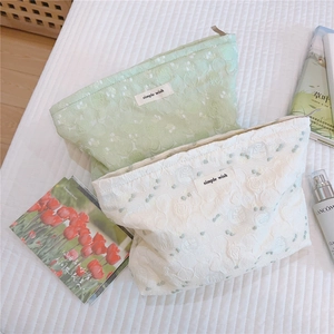 Detail of floral jacquard fabric on canvas cosmetic bags with simple wish label and zipper