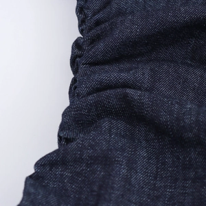 Vista macro dettagliata della trama del tessuto denim blu scuro e cuciture dell'abito