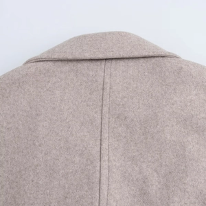Macro detail of high-quality oatmeal wool coat collar showing fabric texture and stitching