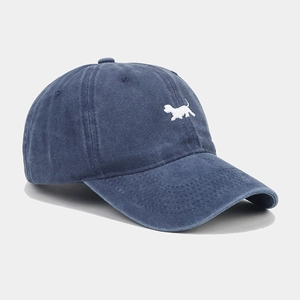 Dettaglio del ricamo a forma di cucciolo bianco su berretto da baseball blu lavato