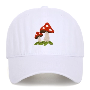 Close-up of vibrant red mushroom embroidery on a white vintage washed cotton baseball cap