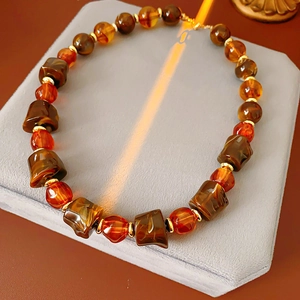 Macro detail of irregular geometric amber beads and gold spacers on a vintage necklace
