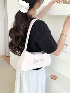 Minimalistische weiße PU-Unterarmtasche mit Schleife, präsentiert von einem Model