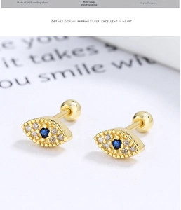 Macro detail of gold 925 sterling silver evil eye stud with blue zircon and ball screw back