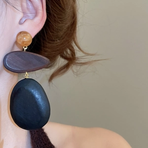 Close-up of vintage resin and wood teardrop earrings worn on model for ethnic style look
