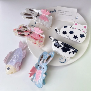 Detailed close-up of acetate animal hair claws featuring rabbit and cow patterns