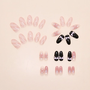 Detail of pink plaid press-on nails with 3D bows, rhinestones and star glitter accents