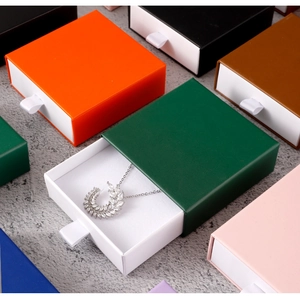 Detail of multi-color drawer jewelry boxes with inner sponge and a silver necklace inside