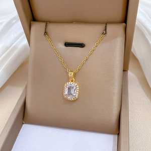 Macro shot of gold square zircon pendant necklace on luxury velvet jewelry box