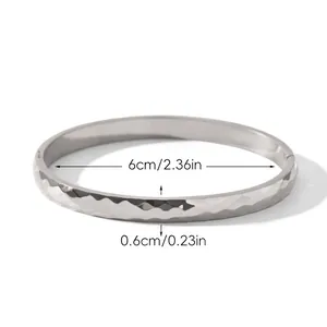 Détail d'un jonc en acier inoxydable plaqué or 18 carats avec texture diamantée