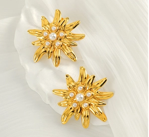 Close-up of golden sunflower earrings featuring elegant white pearls and vintage metal petals