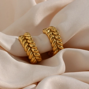 Macro shot of 18K gold-plated C-shaped earrings with wheat pattern texture detail