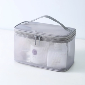 Gray mesh toiletry bag with top handle and double zipper for portable cosmetics storage