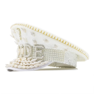 Detail of white sequin captain hat with BRIDE lettering and sea shell brim decorations