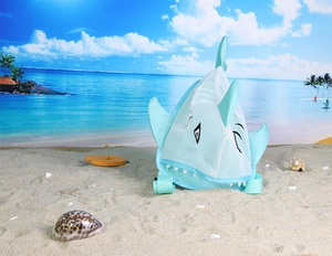 Blue shark mesh beach bag for kids placed on sand with shells and ocean background