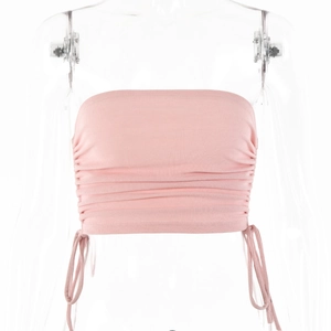 Vue détaillée d'un haut bustier en maille côtelée rose avec des cordons latéraux