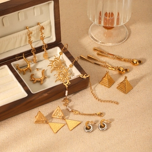 Golden stainless steel jewelry set with Egyptian sun and pyramid designs in a wood box