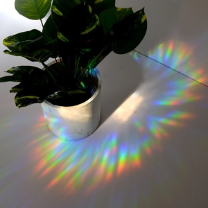 Rainbow prism light effects cast on table from a suncatcher static glass sticker